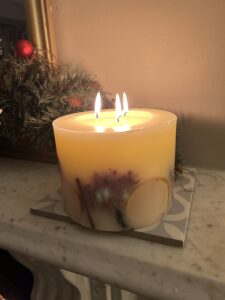 Candle burning on mantlepiece at Christmas
